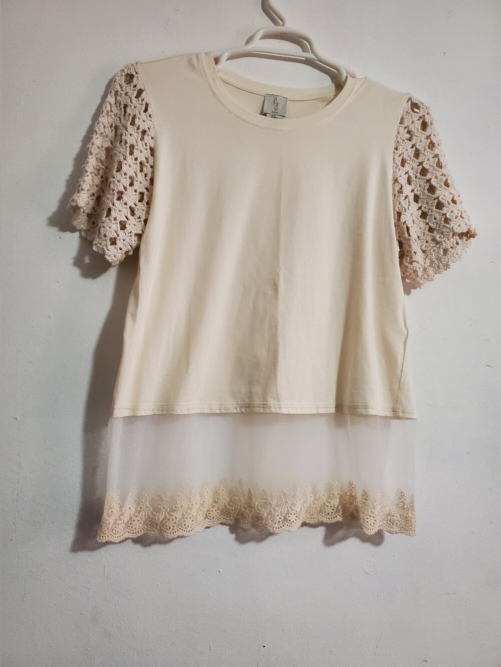 Joie blouse features distinctive crocheted short sleeves and a delicate lace hem